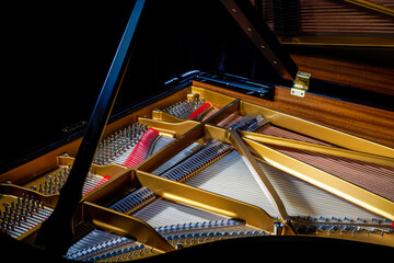A close-up of the internal string structure of a top grand piano
