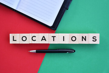 'Locations' word on wood block with red and green background flat lay concept.