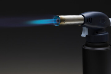 Blue flame from a gas torch burner on black background