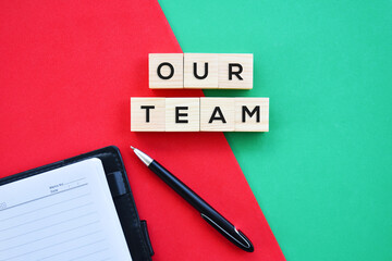 'Our Team' word on wood block with red and green background flat lay concept.