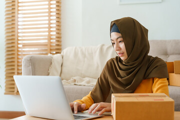 Muslim young women wear hijab check order customer address on computer at home 