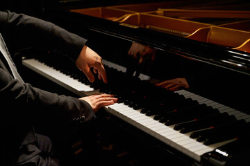 A pianist plays on the grand piano