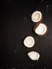 Half of coconuts isolated on black background. Coconut cream. Top View. 