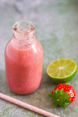 Fototapeta na wymiar Strawberry smoothie in bottle on metal background