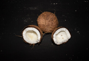 Half of coconuts isolated on black background. Coconut cream. Top View. 