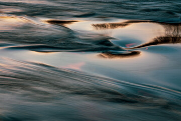 Long exposure of a river at sunset .