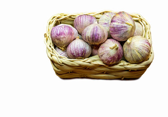 Pile of fresh garlic in a wooden basket, all is isolated on white background