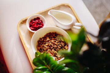Morning breakfast, granola stands on the table, in greens with candied fruits on a blue background