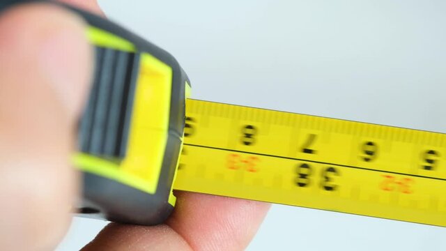Slow motion video of a yellow tape measure.