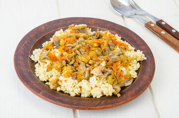 Boiled bulgur groats with stewed vegetables and mushrooms, vegetarian food.