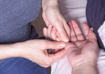the masseur's hands massage the patient's fingers
