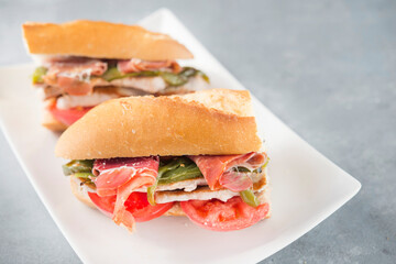 Sandwich Serranito typical in Andalusia with ham, green pepper and grilled pork loin