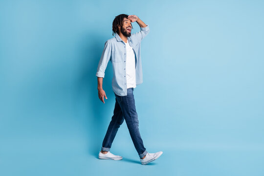 Full Length Body Size Profile Side View Of Nice Cheerful Guy Walking Looking Far Isolated Over Bright Blue Color Background