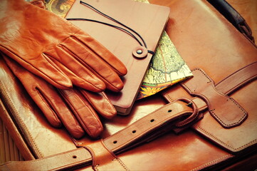 Vintage briefcase with leather gloves and old map

