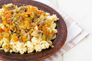 Tasty boiled porridge with vegetables and mushrooms.