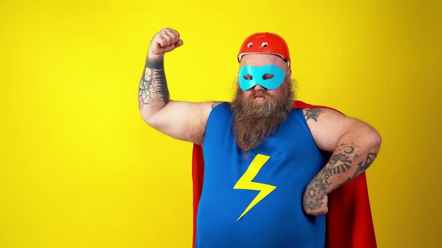 Chubby super hero in action. Masked hipster man on colored background