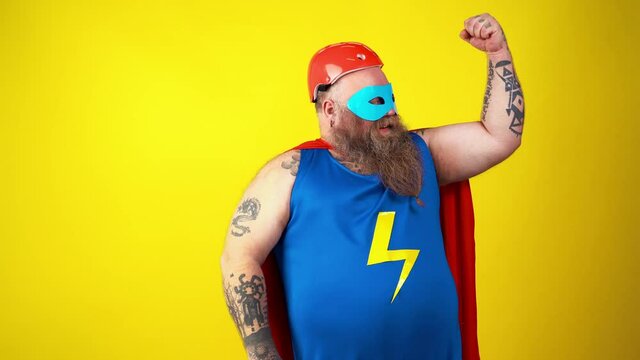 Chubby super hero in action. Masked hipster man on colored background