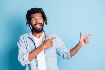 Portrait of attractive cheerful guy demonstrating copy space good offer solution isolated over bright blue color background