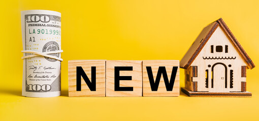 Obraz premium NEW with house miniature model and money on a yellow background. Investment, real estate, home, housing, earnings, financial concept