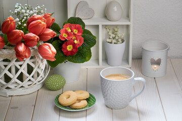 Springtime background with coffee, cookies and spring decorations. Display cabinet with springtime...
