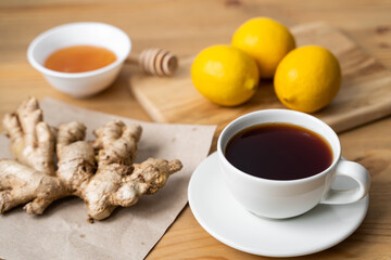 Cup of ginger tea with lemon on wooden table