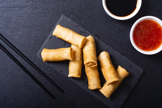 Fried spring rolls with vegetables on rustic background