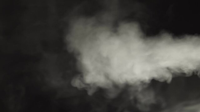 White steam from water on a black background directed to the left