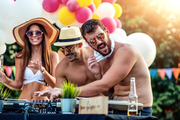 Group of friends have fun by the pool