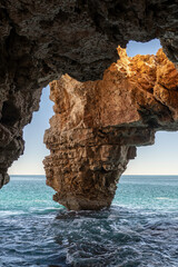 Cave with stone column on the coast formed by waves erosion