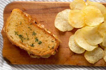 Homemade French Onion Melt Cheese Sandwich with Chips on a rustic wooden board, top view. Flat lay, overhead, from above.