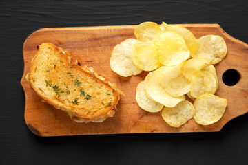 Homemade French Onion Melt Cheese Sandwich with Chips on a rustic wooden board on a black background, top view. Flat lay, overhead, from above.