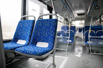 Empty bus interior. Blue seats without passengers. Public transport. Transportation of passengers by public transport. Ergonomic interior of the bus. Travel to other cities. © Семен Саливанчук