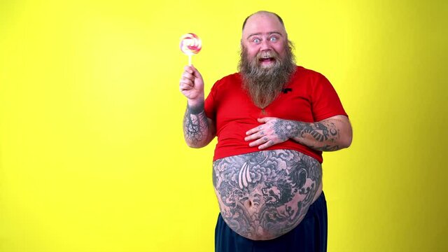 Happy chubby man eating sweets. 