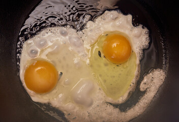Fried two eggs in a frying pan close up