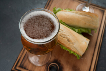 Sandwiches and beer on a wooden table, close up