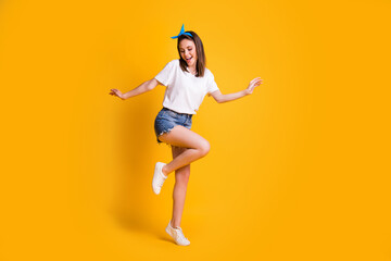 Fototapeta na wymiar Full length body size view of fit cheerful brown-haired girl jumping dancing enjoying free time isolated over bright yellow color background