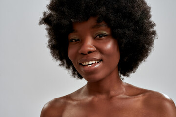 Close up portrait of cheerful african american young woman with afro hair and perfect smooth...