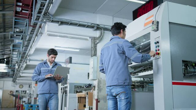 specialist worker engineer team control and operate printing package lable machine with computer screen with concentrate and focus industrial factory machinery ideas concept