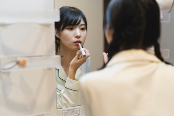 朝のヘアメイクをする女性