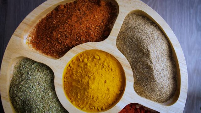 Spices footage.Various Indian Spices on wooden table.Spice rotated on wood table.turmeric, red pepper, pepper, chilli and oregano