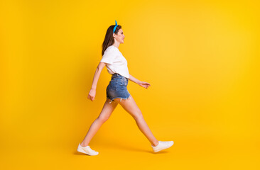 Fototapeta na wymiar Full body profile side photo of fit young happy woman walk free time look copyspace isolated on yellow color background