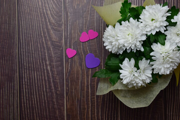 Hearts, love, Valentine. Plant with white flowers on a rustic brown table. Copy space.
