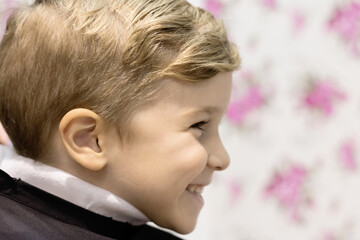 Profile view of happy boy at hairdresser.