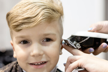 Close-up of kid during haircut at the salon.