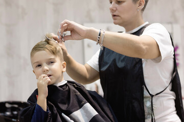 Small boy getting a haircut at the salon.