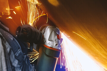 wind energy pile production, flying sparks from angle grinder.