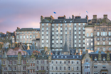 Fototapeta premium Sunset or sunrise cityscape view of the Edinburgh skyline and old town tenement buildings off the Royal Mile in the capital city of Scotland, UK.