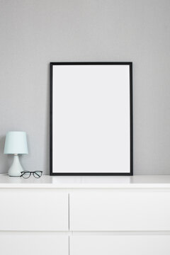 Blank picture frame mockup on gray wall. Minimal living room design. View of modern scandinavian style interior. Home staging and minimalism concept.	
