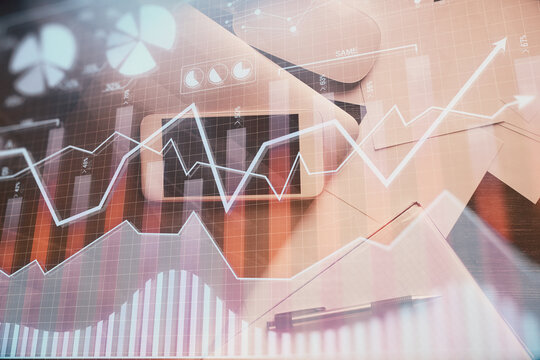 Multi exposure of forex graph hologram over desktop with phone. Top view. Mobile trade platform concept.