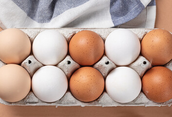 fresh eggs in a carton of three colors. Top view